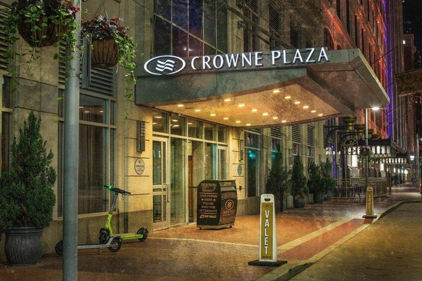 A hotel entrance with a marquee sign, a scooter, and a valet sign. 2