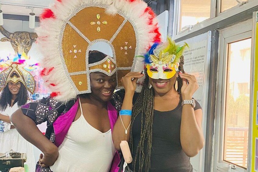 Two people wearing elaborate masks and a large decorative headpiece. 3