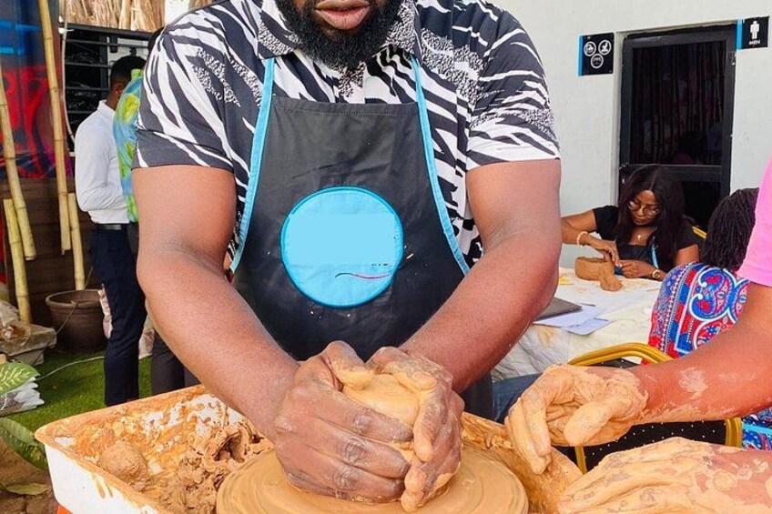 A person shaping dough with hands, wearing an apron, at a food stall. 4