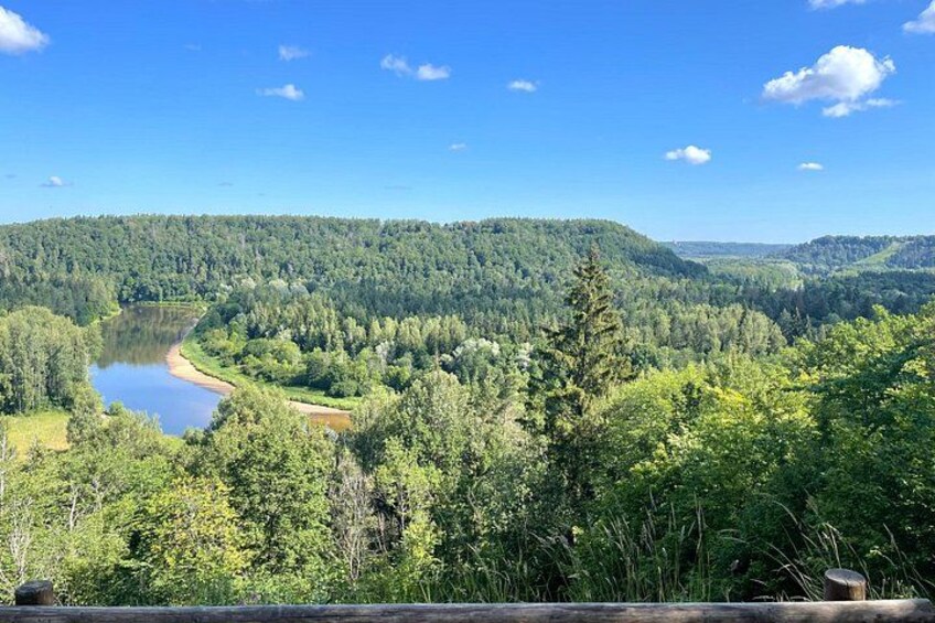 Une rivière serpente à travers une vallée boisée, avec des collines en arrière-plan. 5