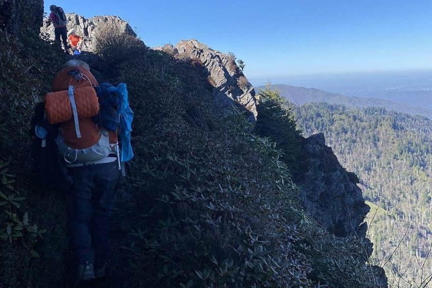 A hiker with a backpack on a mountain trail. 2