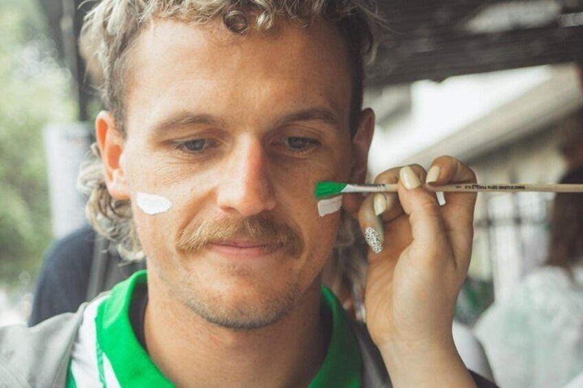 A person holding a paintbrush near their face. 4