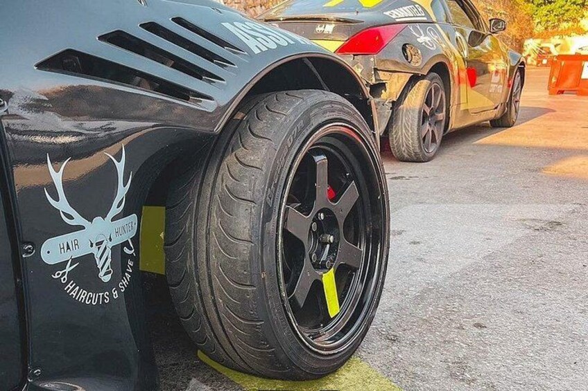 A car with a deer sticker on the side, a custom wheel, and a yellow stripe on the tire. 4