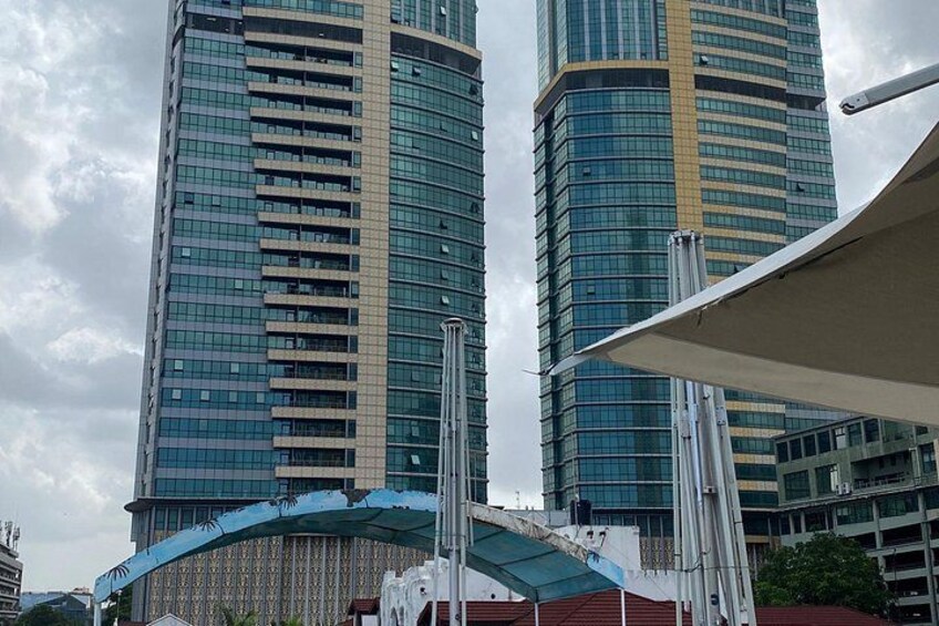 Two tall buildings with reflective glass windows, a curved structure with a blue roof, and a white canopy. 4