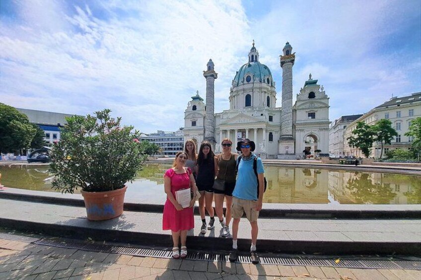 A group of people standing in front of a historic building with domes and towers. 1