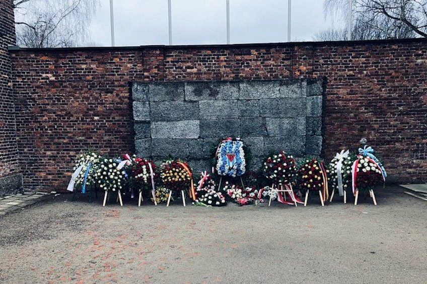 A row of floral tributes against a brick wall. 3