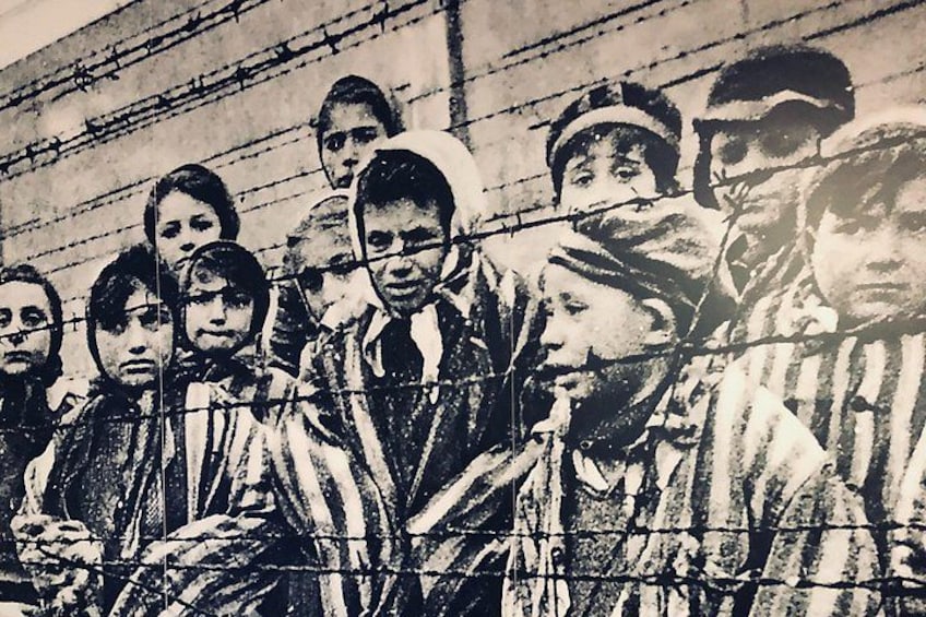 A group of people behind barbed wire, suggesting a restricted or controlled environment. 4