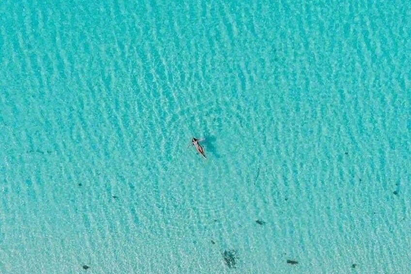 Mar turquesa cristalina con una sola persona nadando. 3