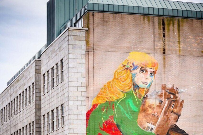 A mural on a building featuring a person with a dog. 5