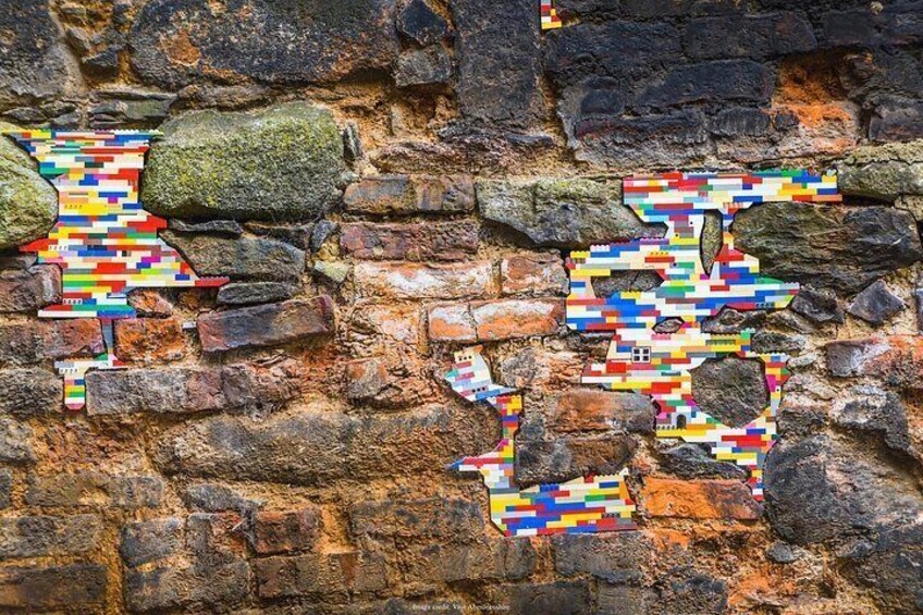 A stone wall with colorful pixelated patterns. 2
