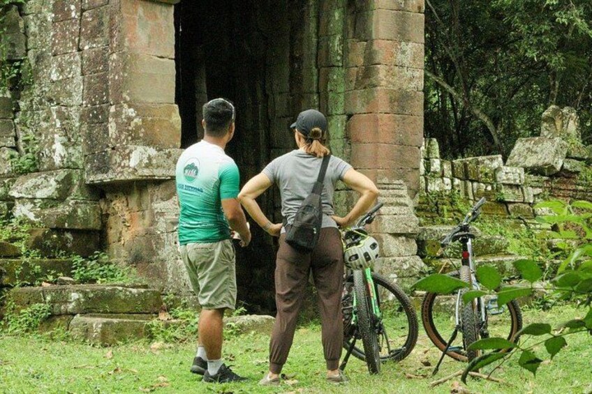 Dos personas cerca de una construcción de piedra con bicicletas. 1