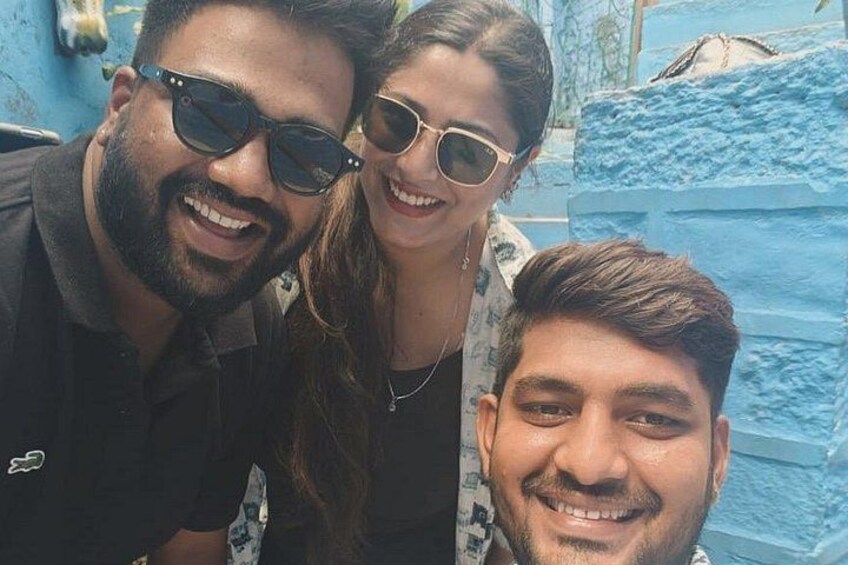 Three people in front of a blue textured wall. 2
