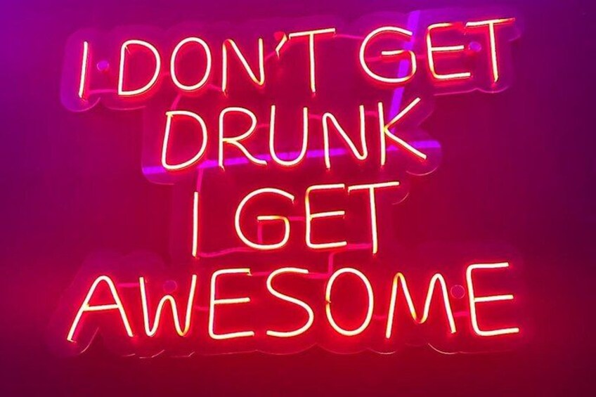 A neon sign with the text 'I DON'T GET DRUNK I GET AWESOME' in red and yellow colors. 2