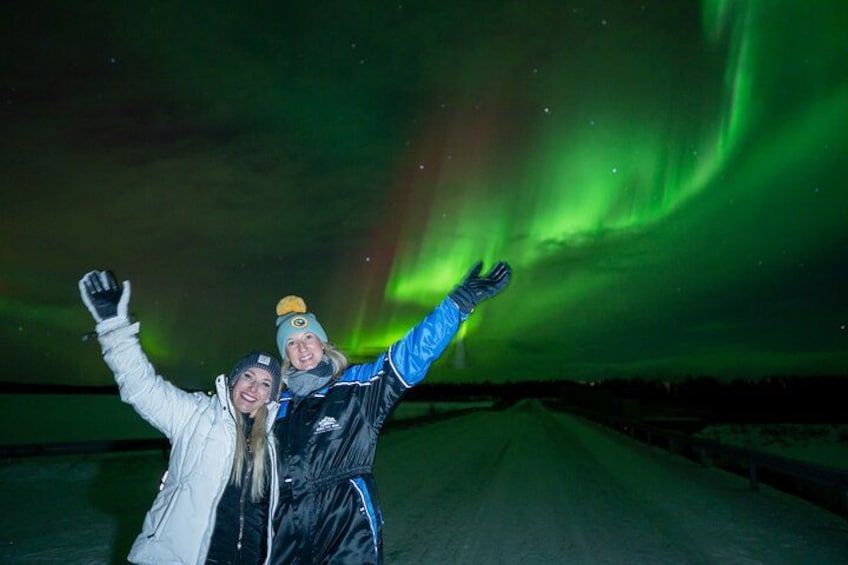 Two people outdoors with a green aurora in the background. 2