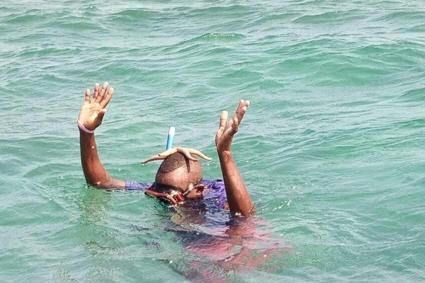 Una persona nuota nell'oceano con le braccia alzate. 2