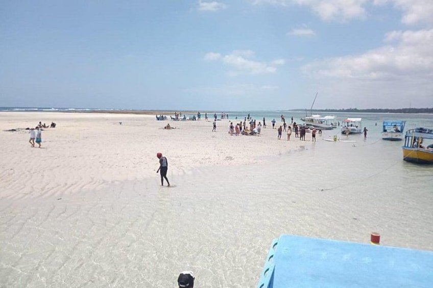 Una spiaggia con persone, barche e cielo sereno. 3