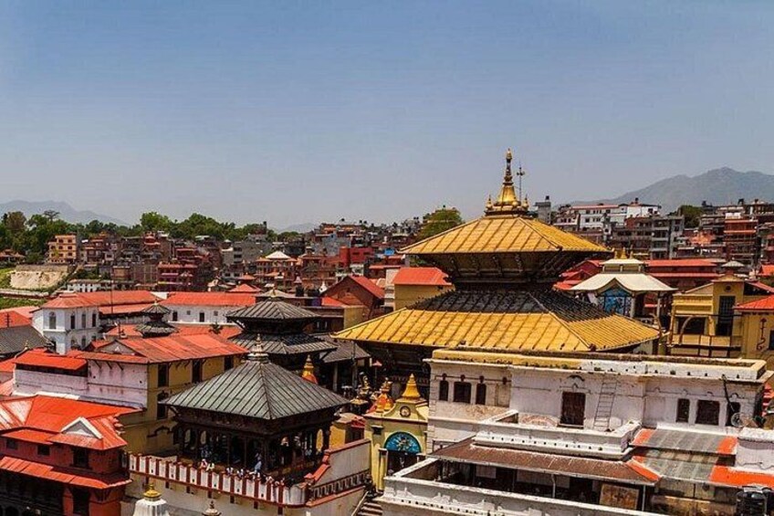 A cityscape with a prominent golden pagoda, traditional buildings, and a mountainous backdrop. 3