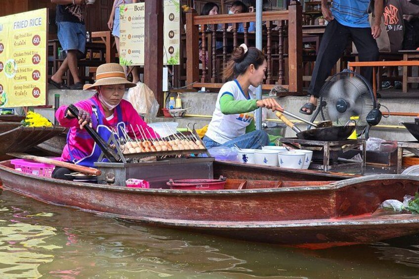 A person cooking on a boat with a fan and cooking utensils. 2