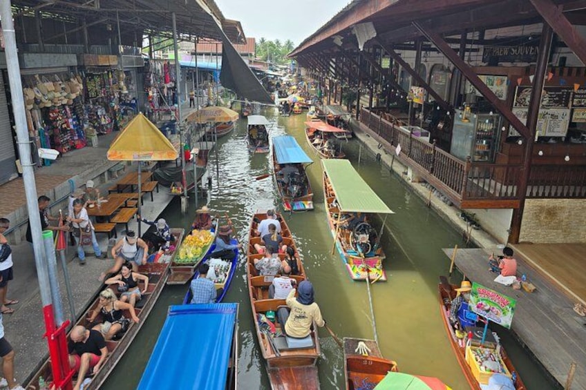 A bustling waterway with boats, canopies, and shops. 5