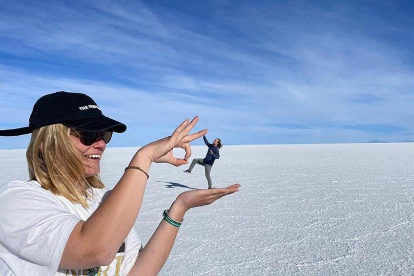 Una persona con camisa blanca y gorra negra de pie sobre una extensión salina bajo un cielo despejado. 1