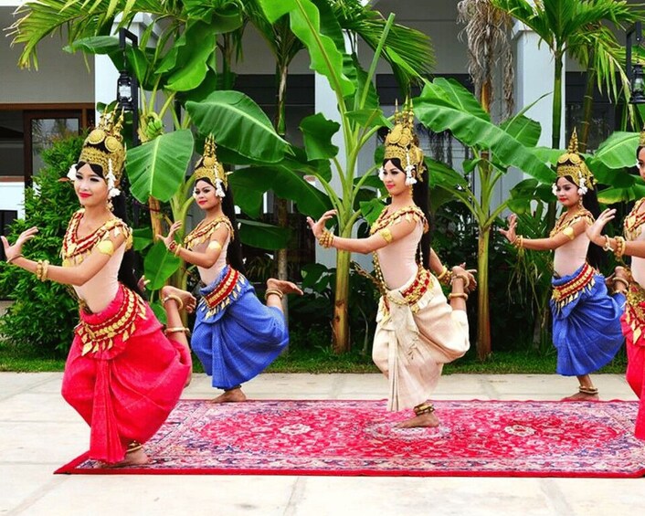 Un grupo de bailarines vestidos con trajes típicos actuando sobre una alfombra con diseños. 2