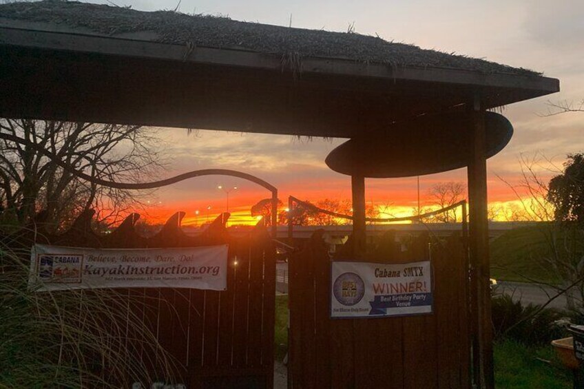 A sunset with a wooden structure and banners advertising a kayak instruction event. 2
