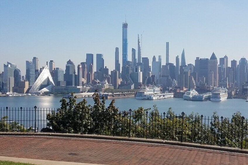 A city skyline with modern skyscrapers, a river with several cruise ships, and a distinctive pyramid-shaped building. 4