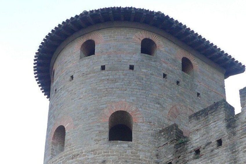 Een stenen toren met rondboogvensters en een afgerond dak. 3