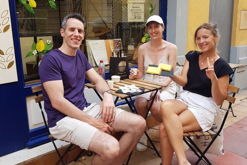 Three people sitting at an outdoor table with a menu and drinks. 5
