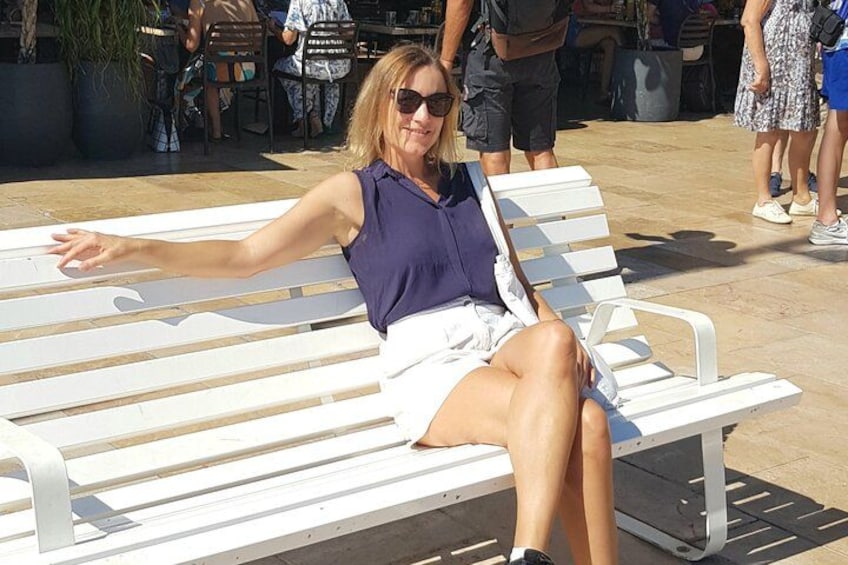 A person sitting on a white bench with arms outstretched. 4