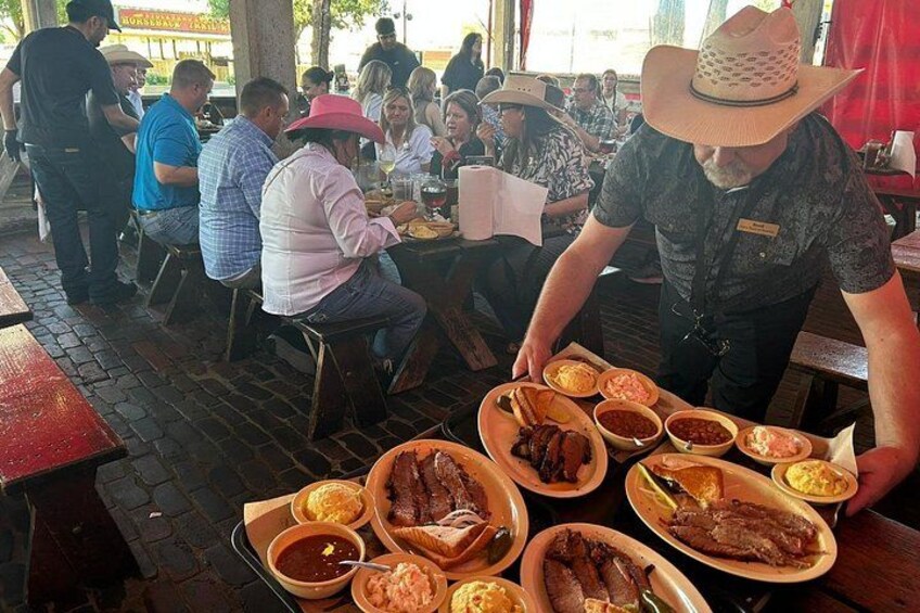 A restaurant with patrons dining and a server attending to them. 4