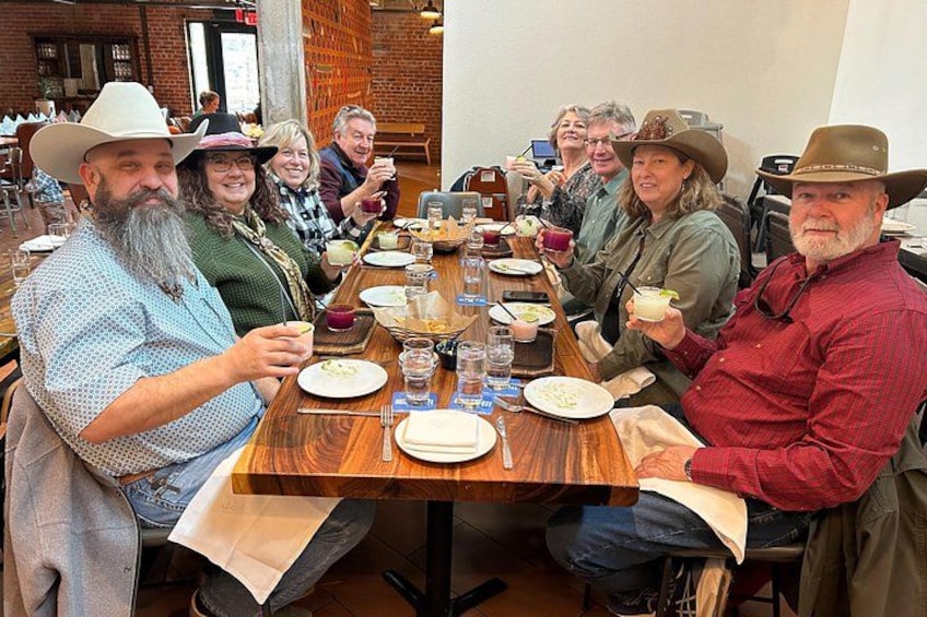 A group of people sitting around a wooden table in a restaurant. 3