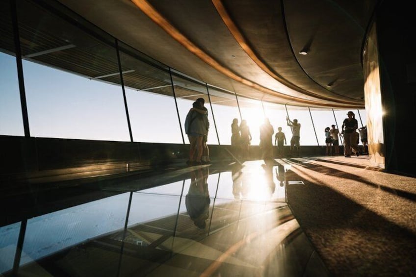A modern architectural interior with reflective floors, curved ceilings, and large windows. 2