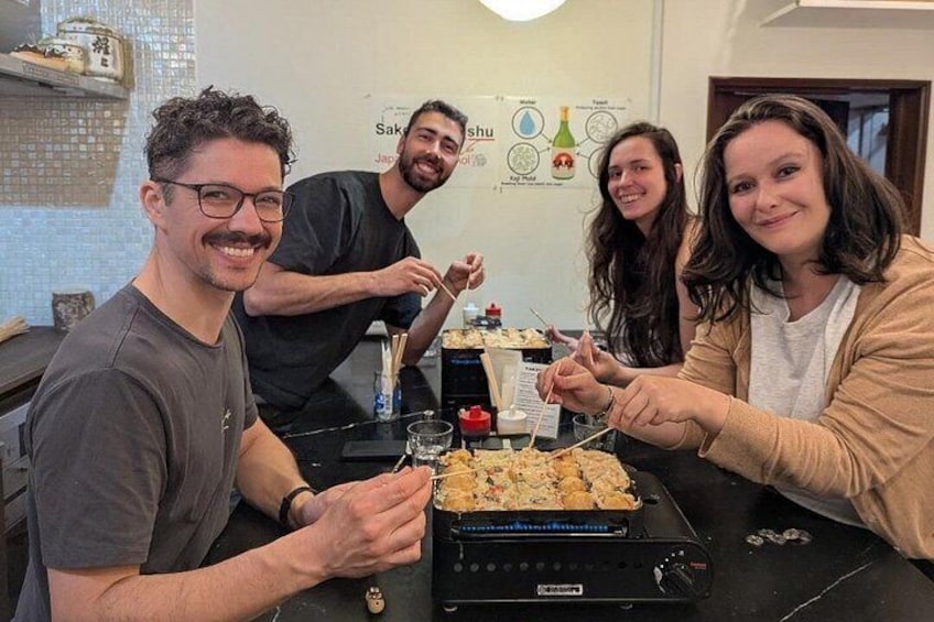 Cuatro personas cenando en una mesa con comida y bebidas. 3