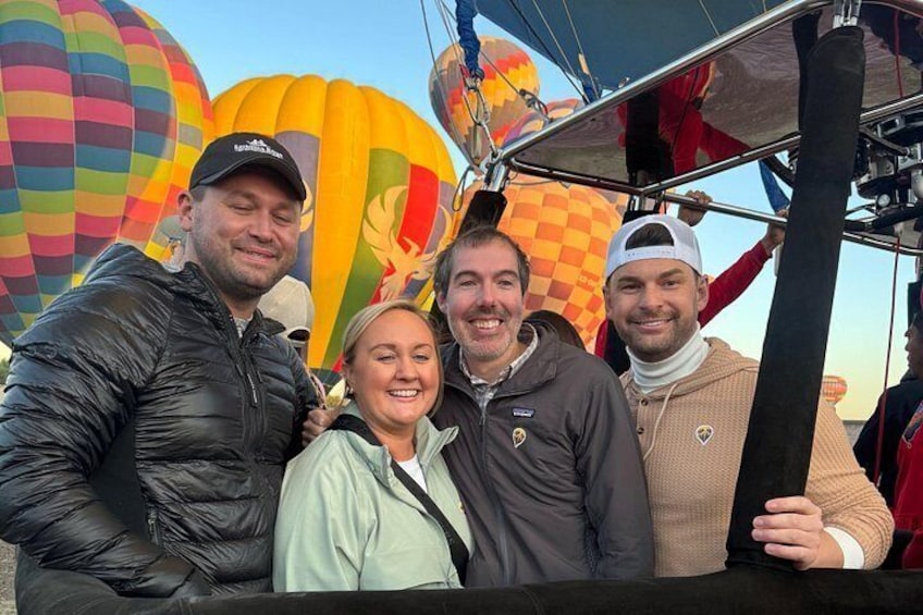 Un grupo de personas de pie frente a globos aerostáticos. 4