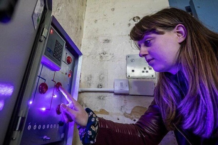 A person interacting with a control panel with illuminated buttons and a keypad. 2
