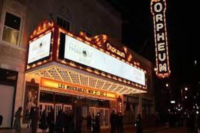 Un théâtre doté d’une enseigne lumineuse et d’un panneau indiquant le nom « ORPHEUM ». 5