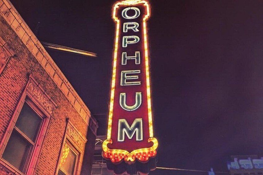 Une enseigne au néon avec le mot « ORPHEUM » sur un bâtiment en briques, de nuit. 1