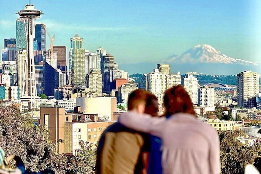 A cityscape with a prominent tower and a mountain in the background. 1