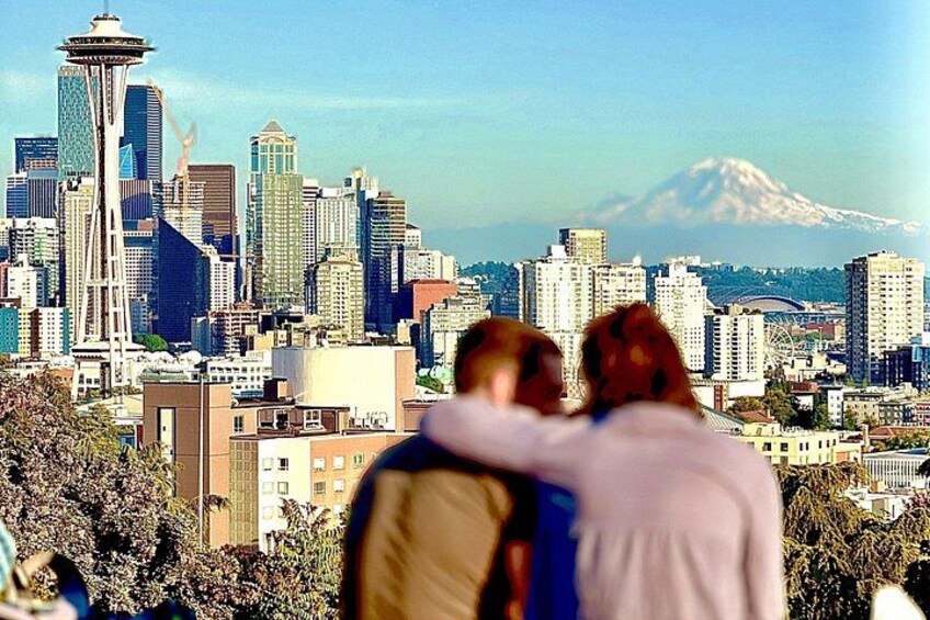A cityscape with a prominent tower and a mountain in the background. 1