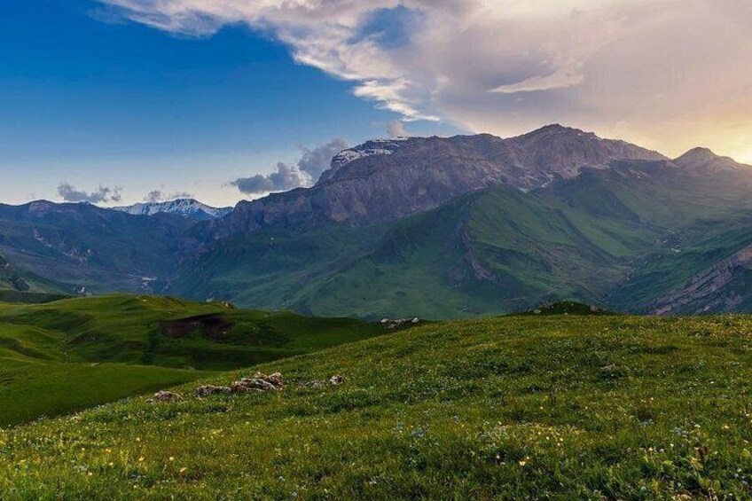 A mountainous landscape with green valleys and a clear sky. 4