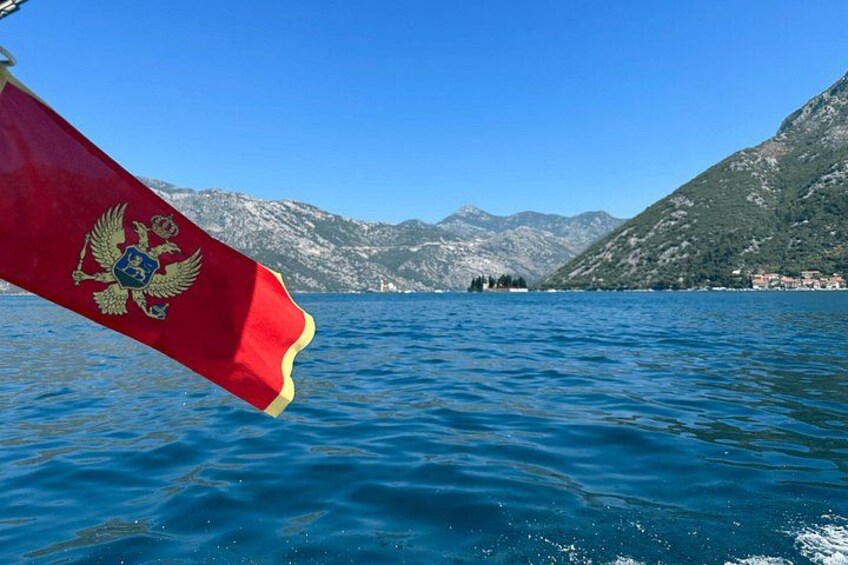 Eine Flagge mit Wappen, einem See und Bergen im Hintergrund. 4