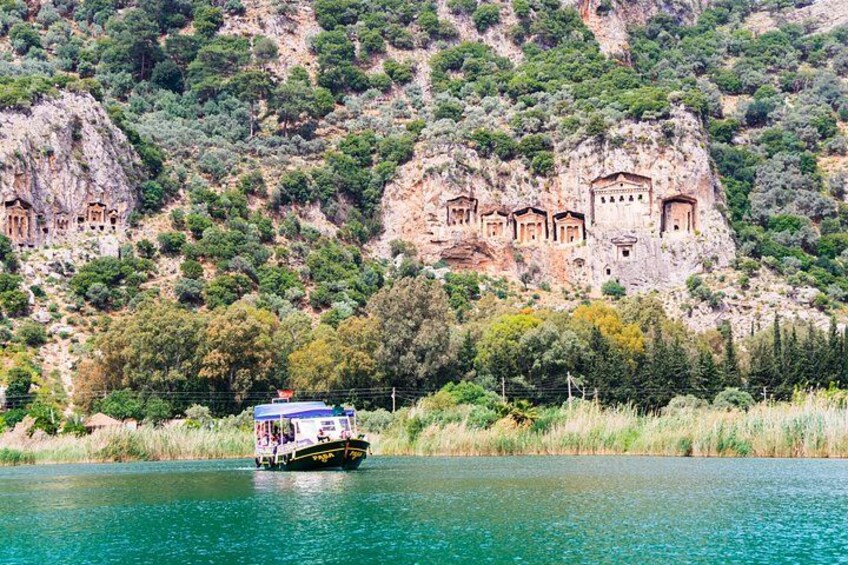 Un bote en un lago con iglesias excavadas en la ladera de una colina. 1