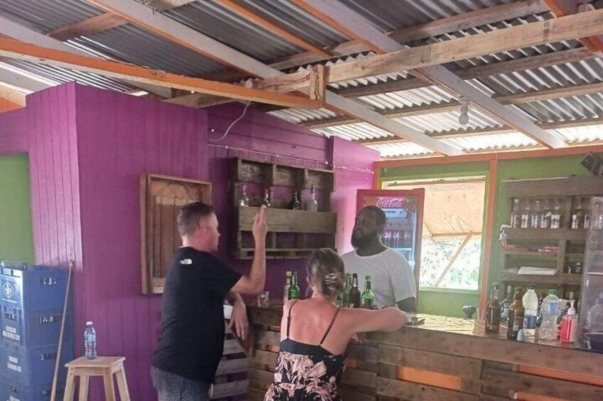 Un bar con estantes de madera y un refrigerador. 2