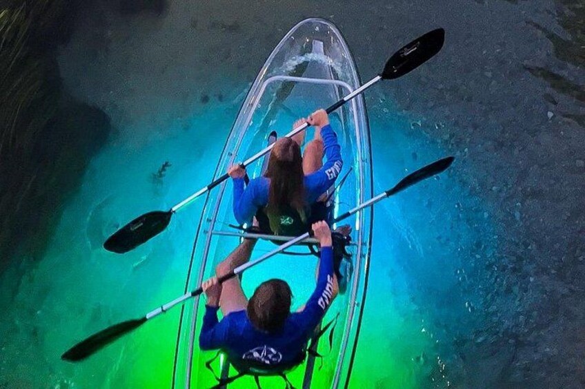 Two people kayaking in a clear, narrow waterway. 1