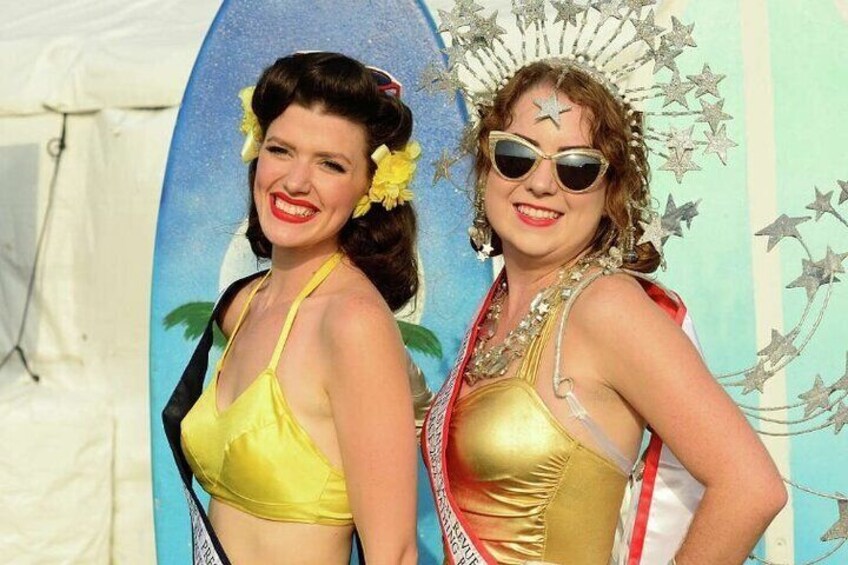 Due persone in costume con una tavola da surf sullo sfondo. 3