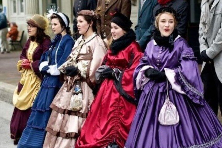 Un gruppo di persone in abiti d'epoca che si trova su una strada. 5