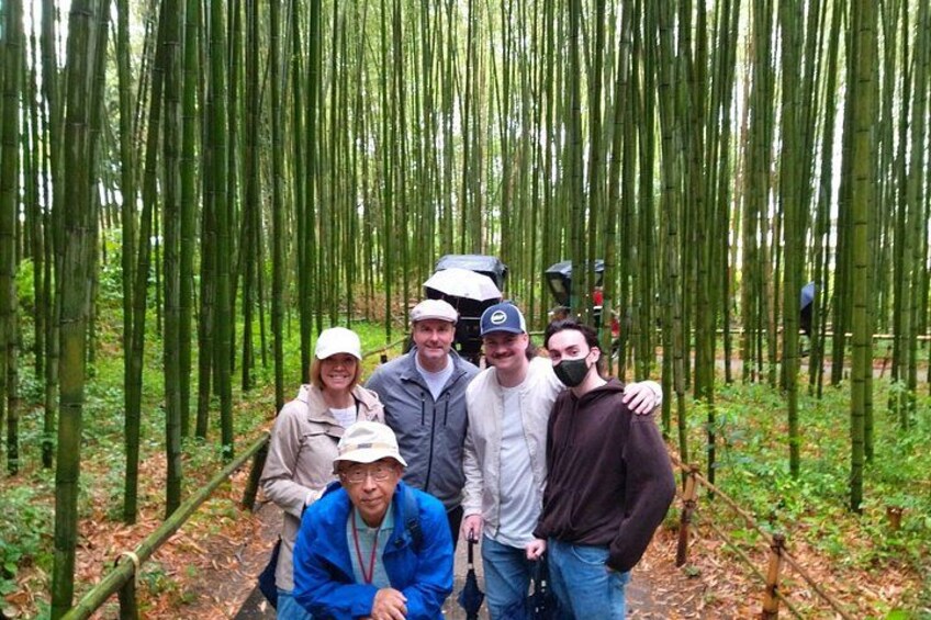 A group of people standing in a bamboo forest. 2