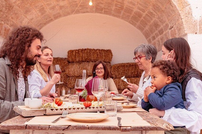 A group of people dining at an outdoor table with hay bales in the background. 3