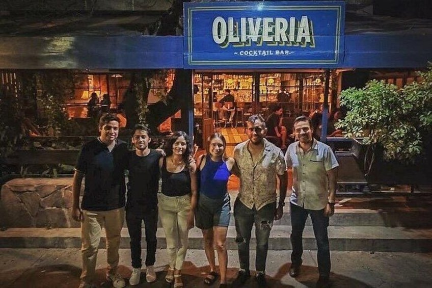 En grupp människor som står framför en bar som heter ”Oliveria”. 5